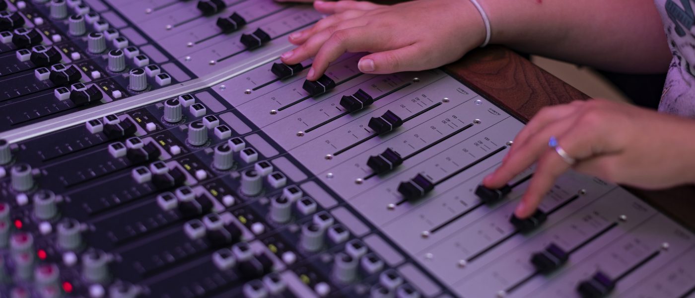 hands at a mixing desk